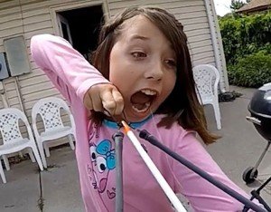 Niña ata su diente a una flecha